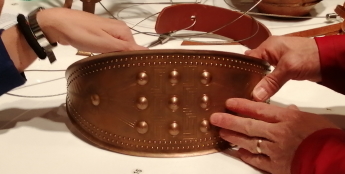 Reproduction d'une ceinture féminine en bronze : détail de l'examen tactile